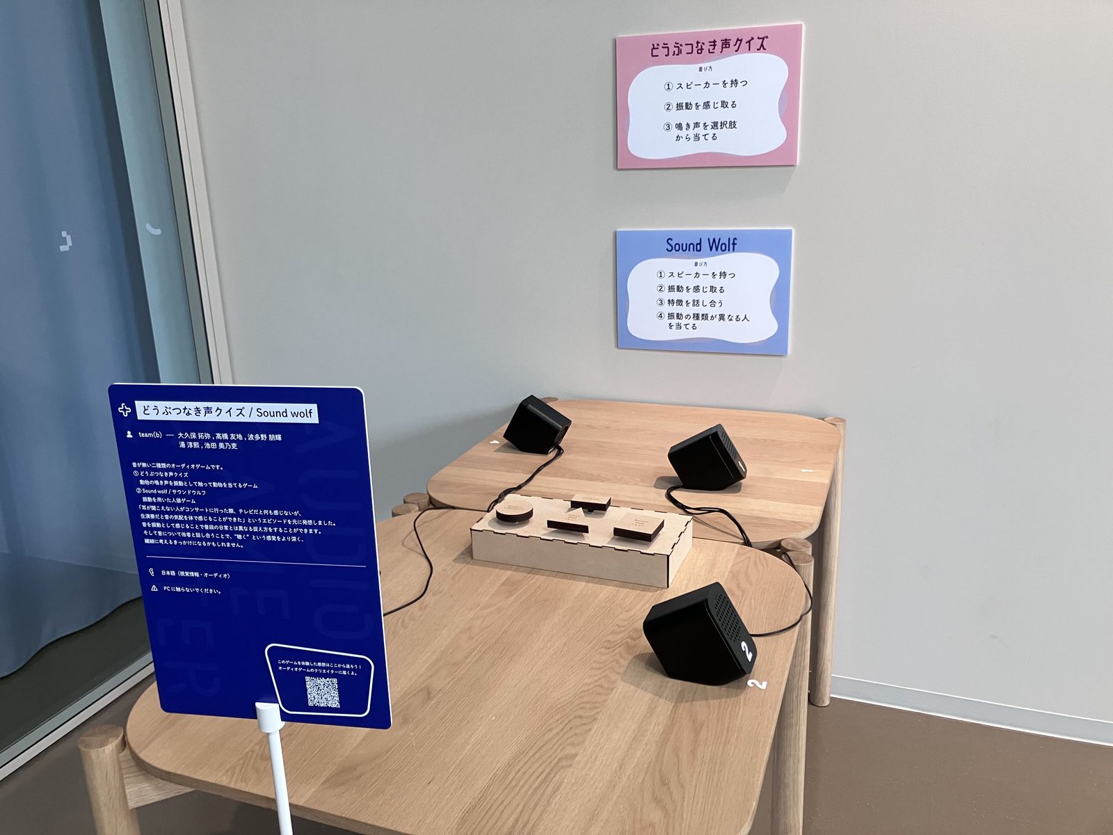 動物鳴き声クイズとサウンドウルフのゲーム。壁にゲームの種類と遊び方が掲示され、机の上にスピーカーとボタンが置かれている。