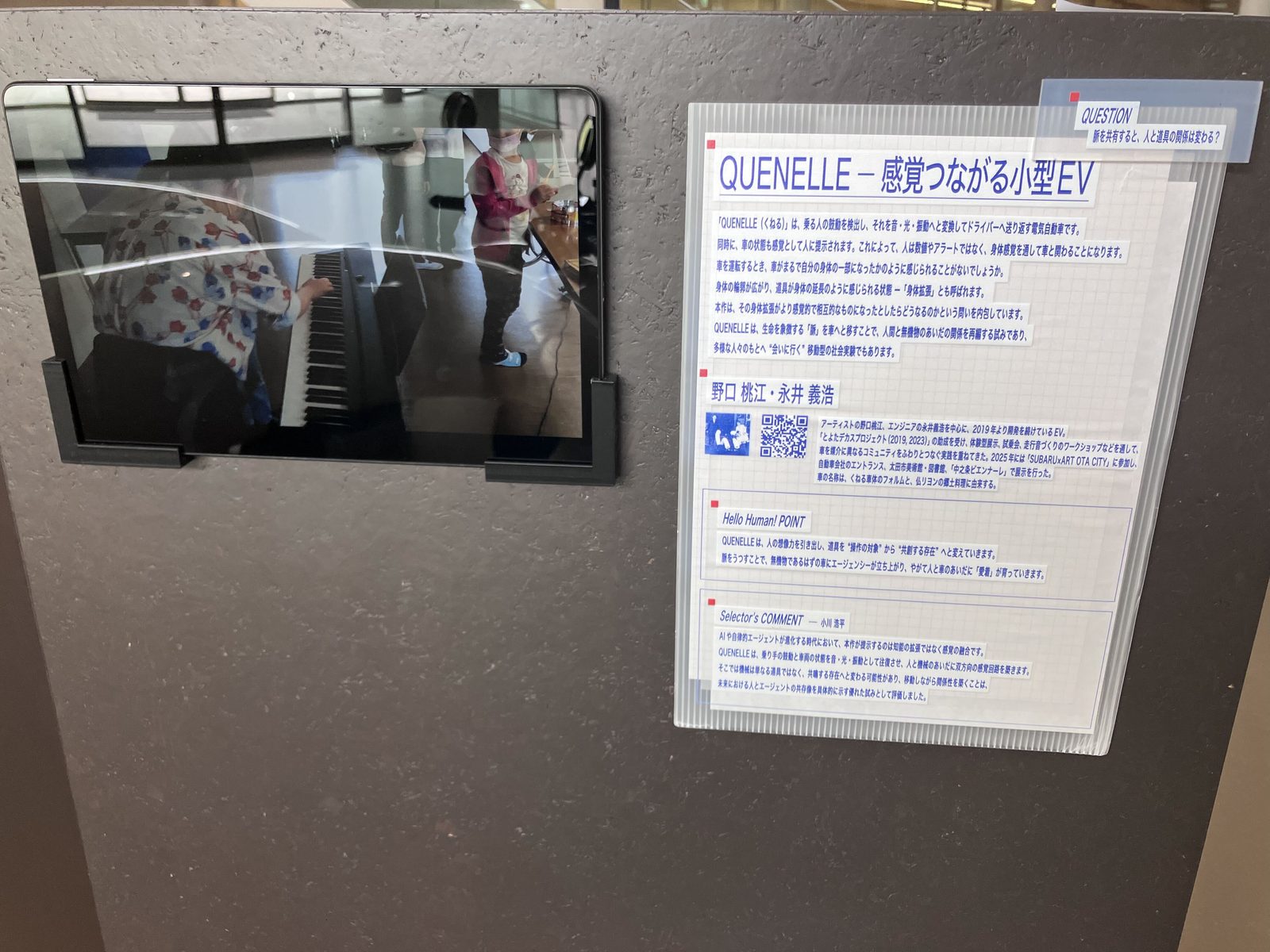 鼓動を伝えるモビリティの説明パネル。「QUENELLE 感覚つながる小型EV」と書かれている。