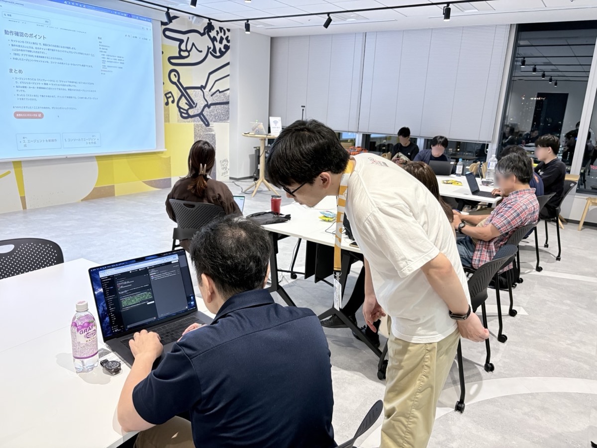 参加者のノートPCをのぞき込んでサポートしている様子