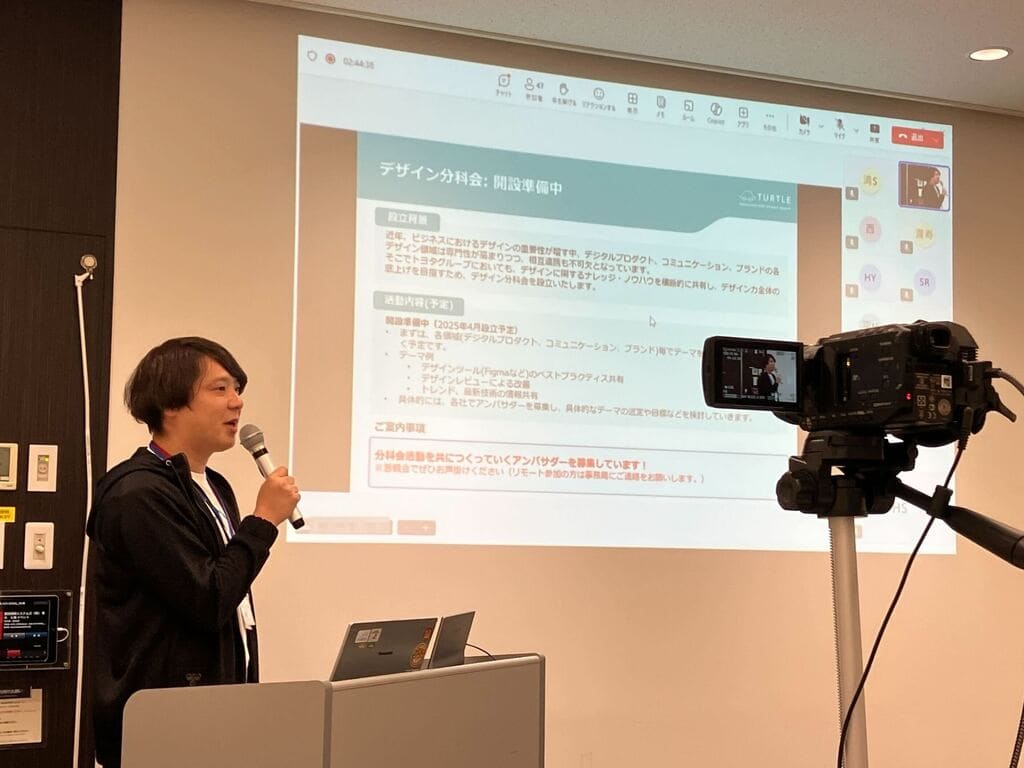 TURTLE総会でのデザイン分科会開設準備発表時の様子、左端に登壇を行う福田が写り込む